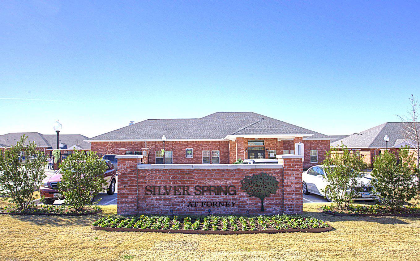 Entrance sign for Union Springs Apartments under clear blue sky.