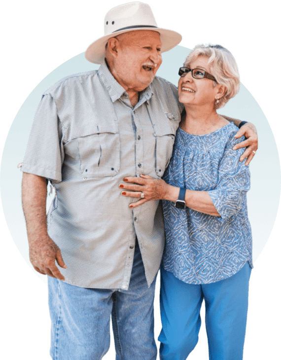 Elderly couple smiling and embracing each other.