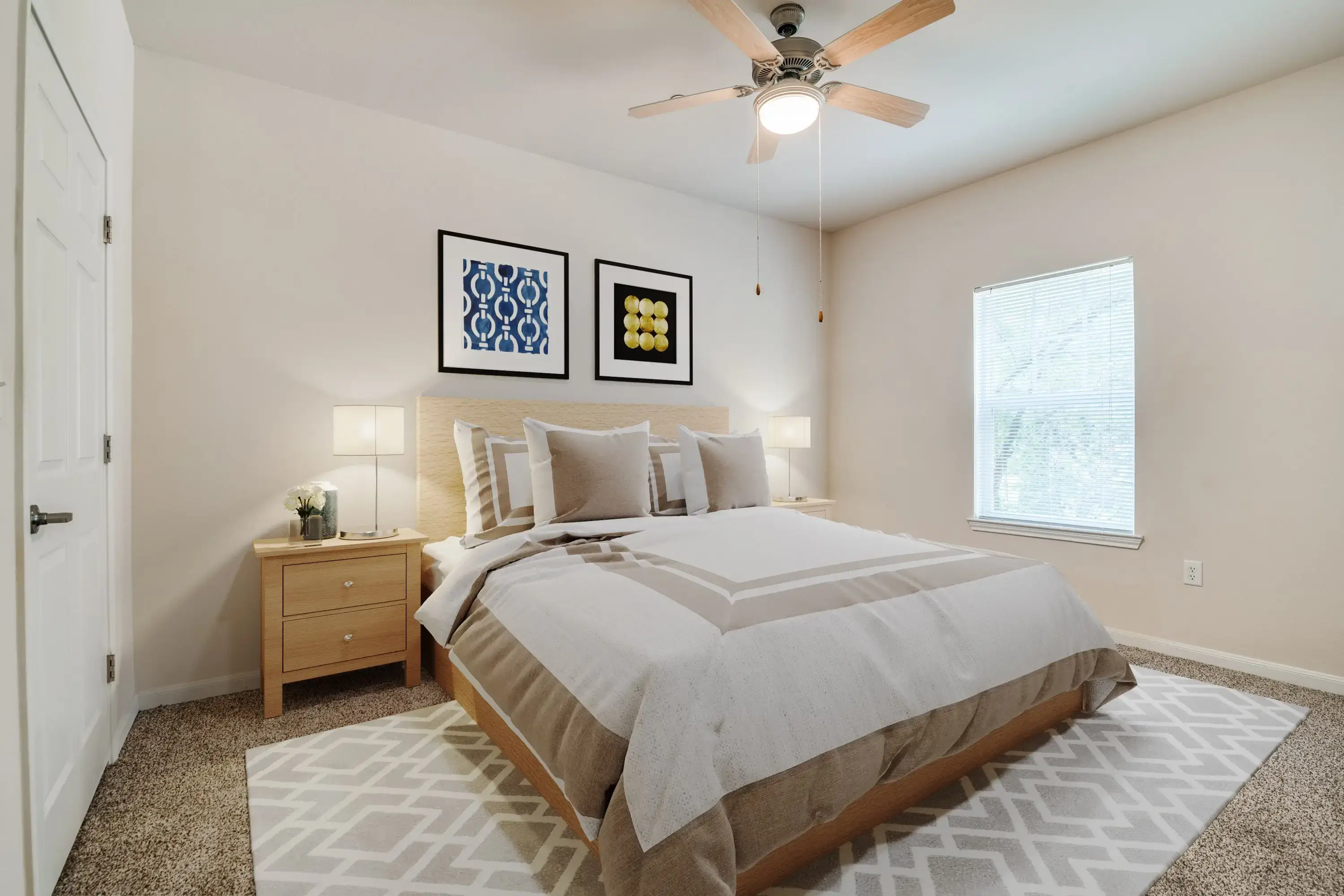 Cozy bedroom with neutral tones, beige bedding, and framed wall art.